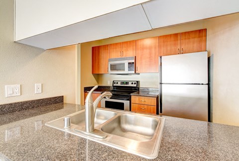 A kitchen with a sink and a refrigerator.
