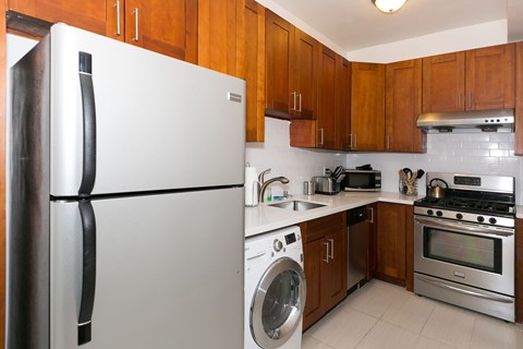 A modern kitchen with a white refrigerator and wooden cabinets.