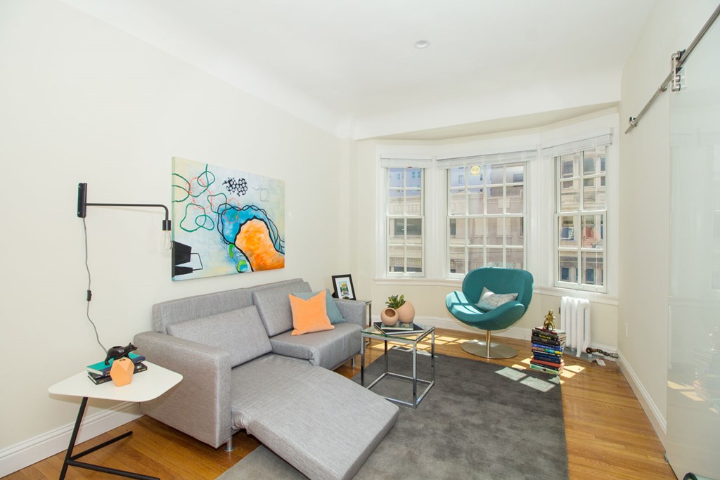 A living room with a grey couch and a green chair.