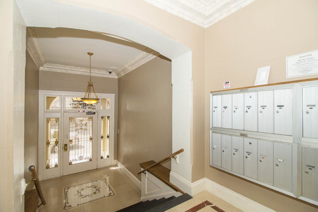 A hallway with a chandelier and a wall of binders.