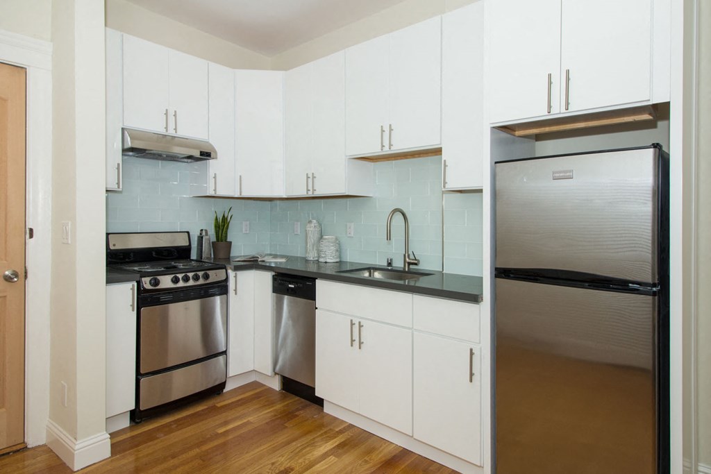 A kitchen with white cabinets and stainless steel appliances.