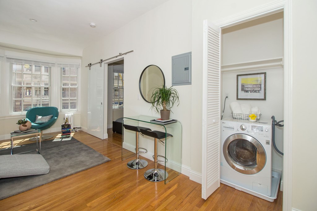 A modern laundry room with a washer and dryer built into the wall.