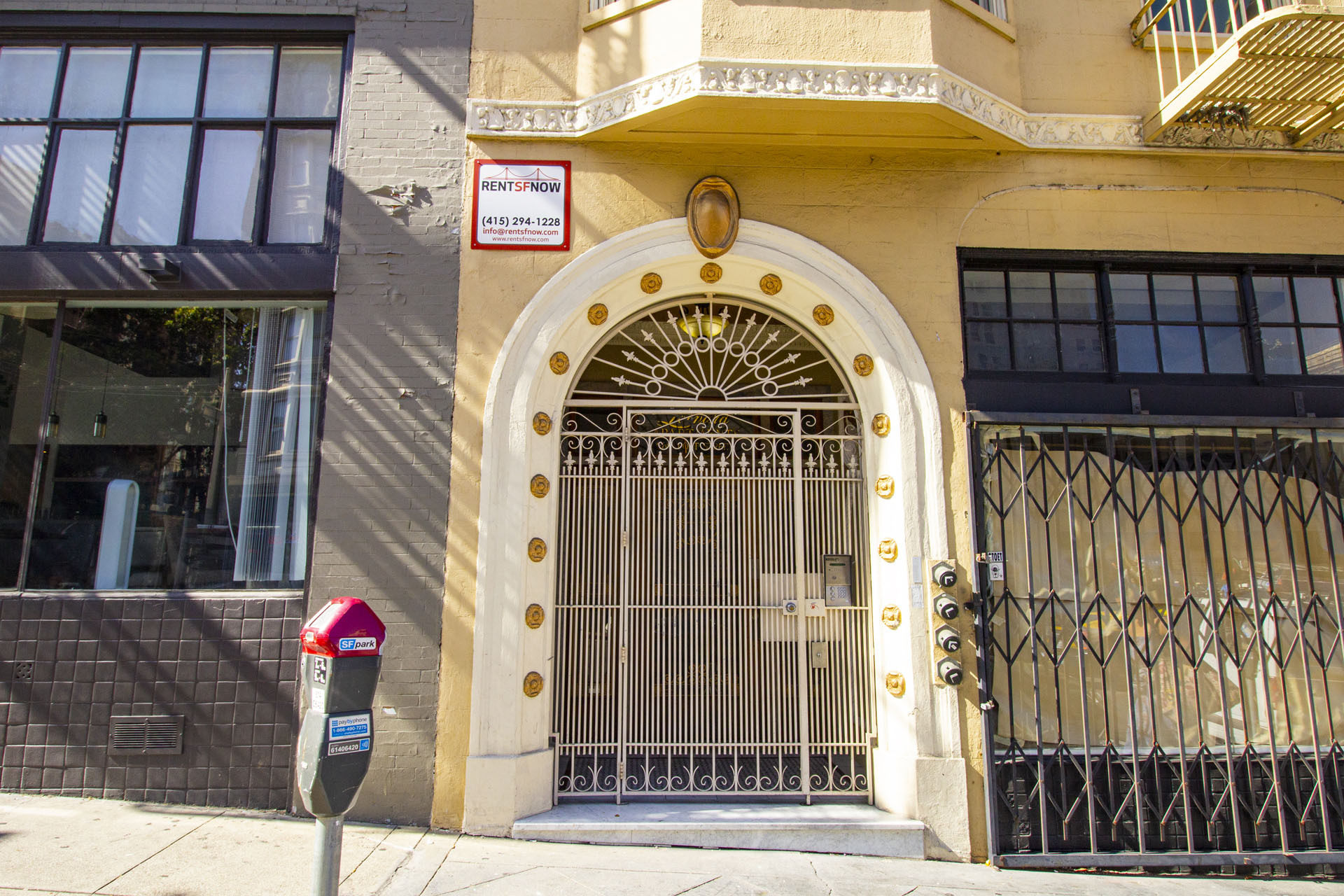 A building with a gate and a sign that says "RENT NOW".