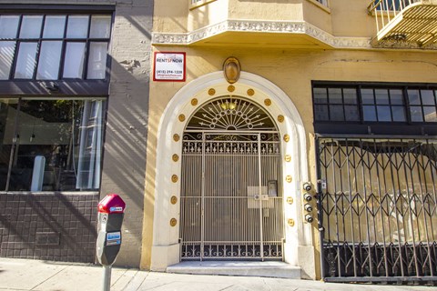 A building with a gate and a sign that says "RENT NOW".