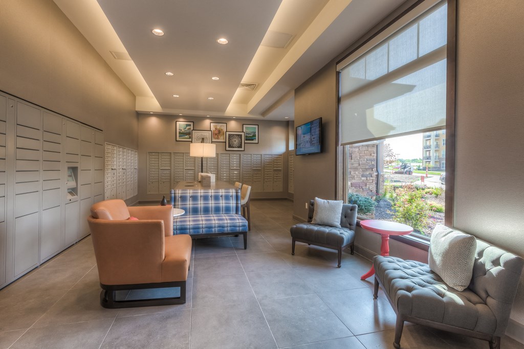 a lounge area with couches chairs and a television  at EdgeWater at City Center, Lenexa, KS