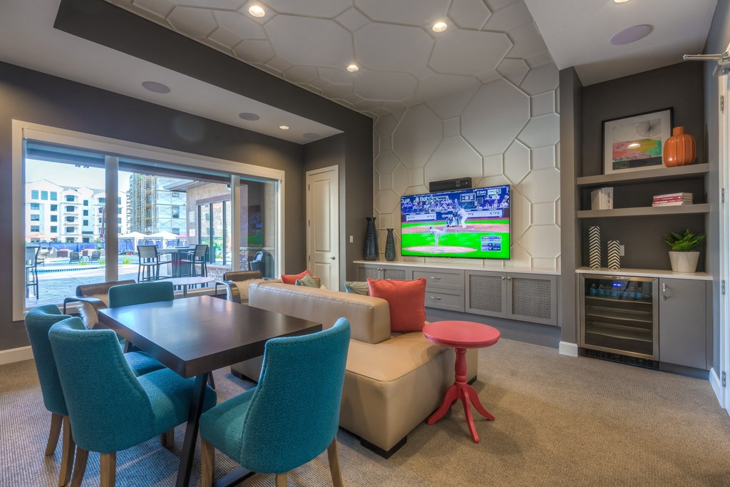 a resident clubhouse with a table and chairs and a flat screen tv at EdgeWater at City Center, Lenexa, KS, 66219
