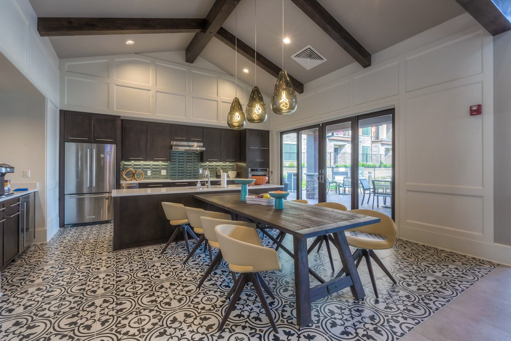 a kitchen with a long wooden table and yellow chairs at EdgeWater at City Center, Kansas, 66219