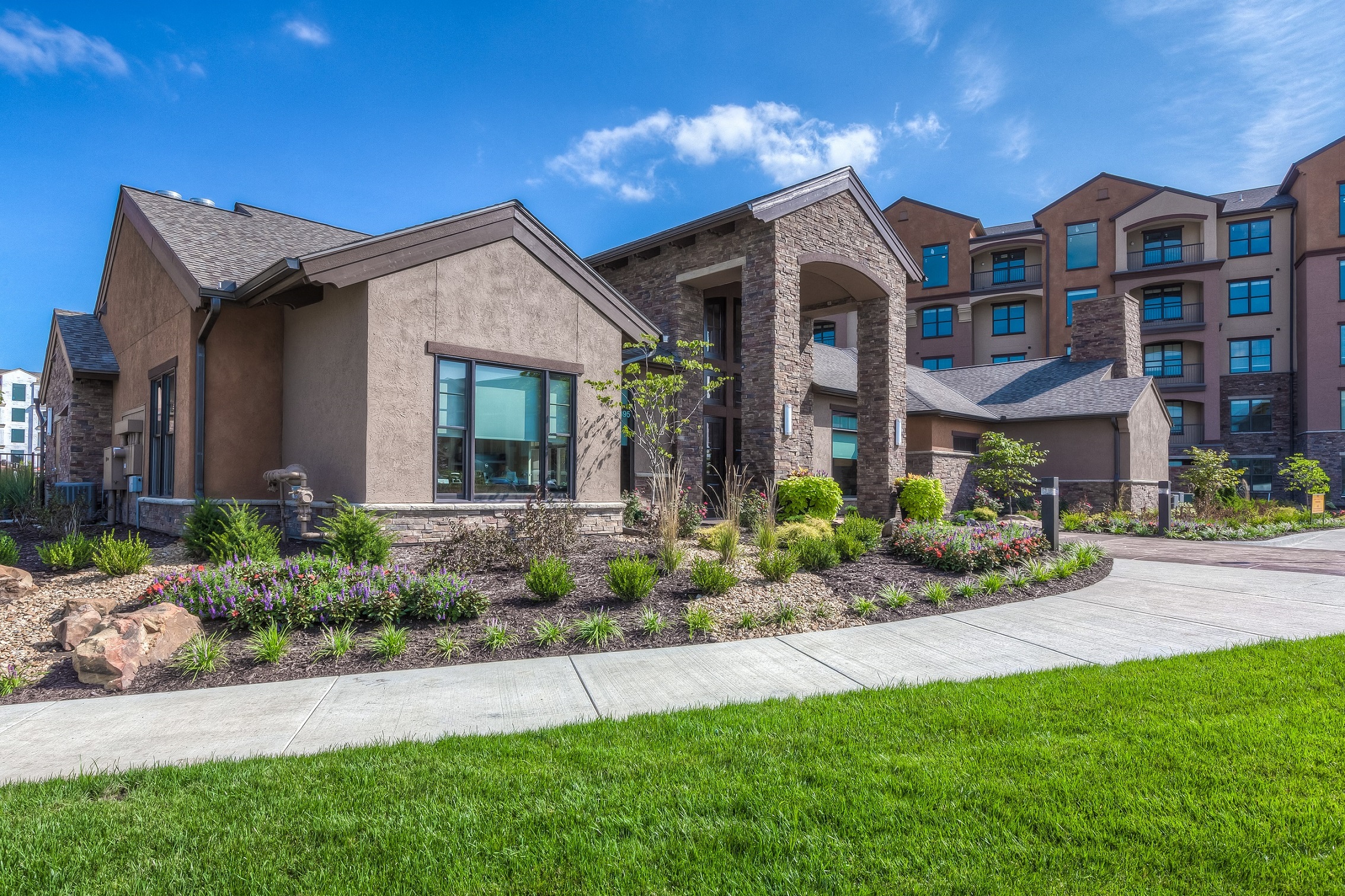 a building with a sidewalk and grass in front of it  at EdgeWater at City Center, Lenexa, 66219