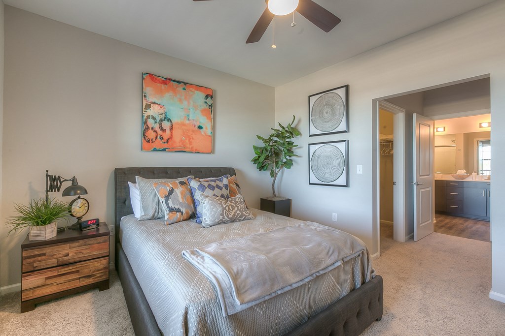bedroom with ceiling fan and hallway to the bathroom bedroom with ceiling fan and hallway to the bathroom at EdgeWater at City Center, Lenexa, KS