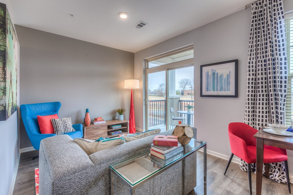 a living room with a couch and a table and a window  at Waterside Residences on Quivira, Lenexa