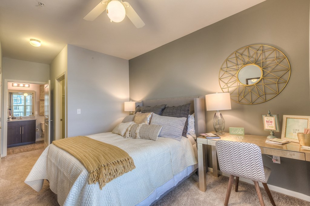 a bedroom with a bed and a desk with a mirror  at Waterside Residences on Quivira, Kansas, 66215