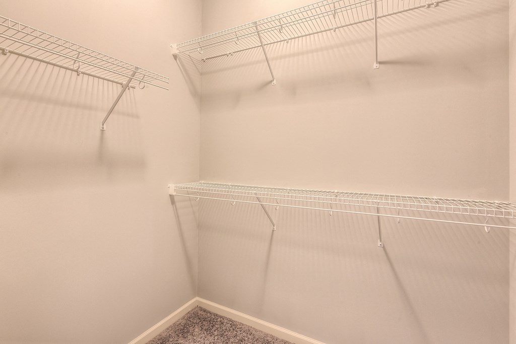 the walk in closet of an apartment with empty shelves  at Waterside Residences on Quivira, Lenexa, KS, 66215
