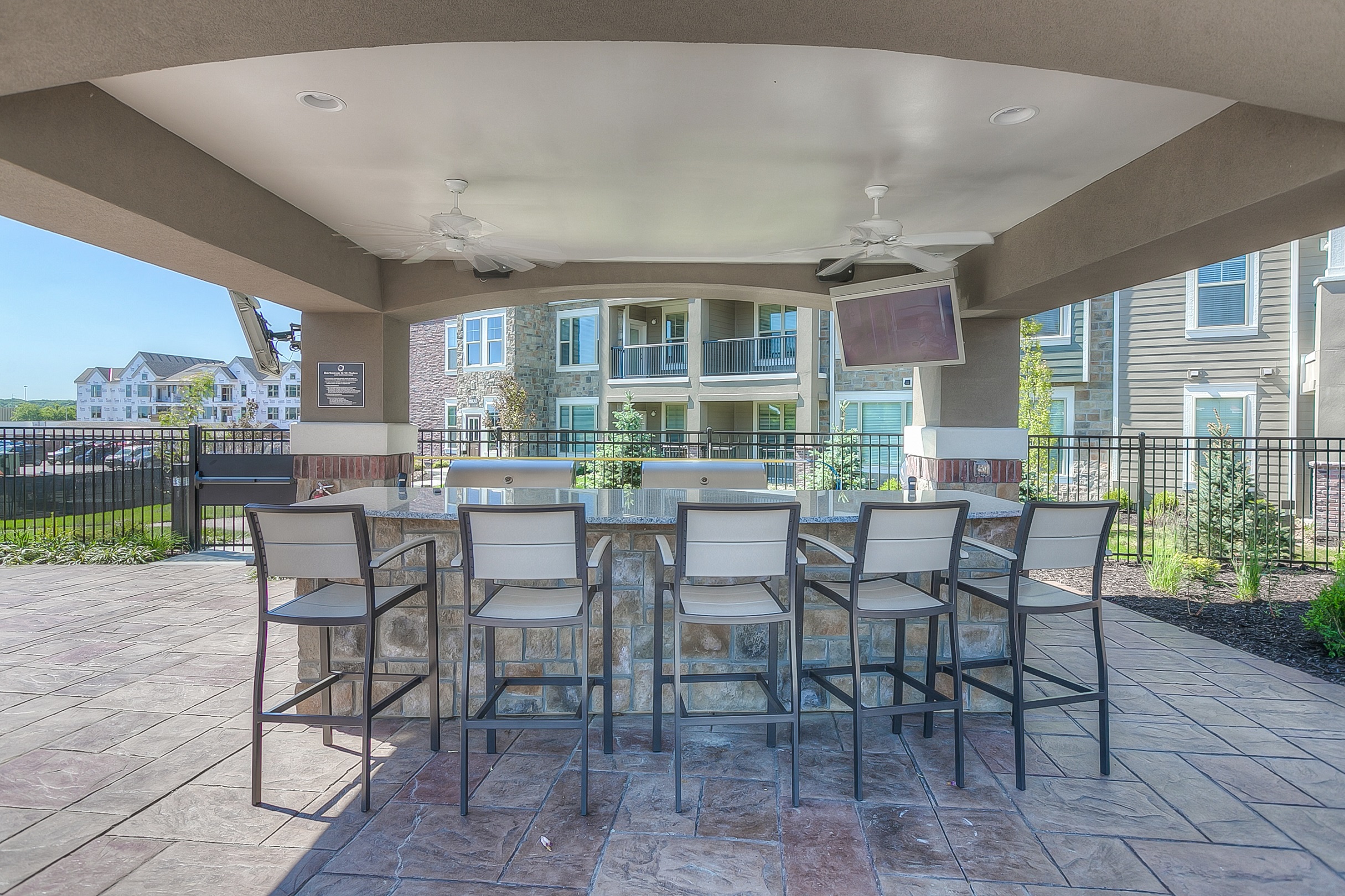 apartment grilling station with two grills and a seating area  at Waterside Residences on Quivira, Lenexa, KS, 66215