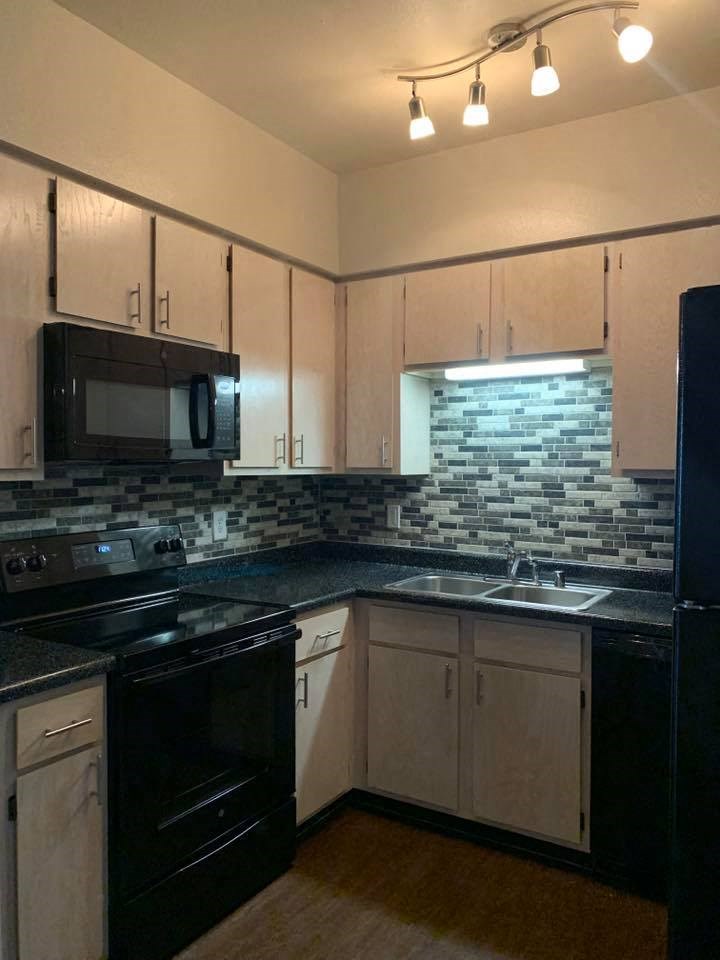 a kitchen with black appliances and white cabinets
