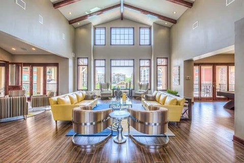 a large living room with yellow couches and tables