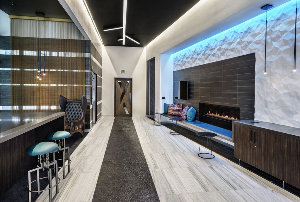 a lobby with a fireplace and a seating area with stools