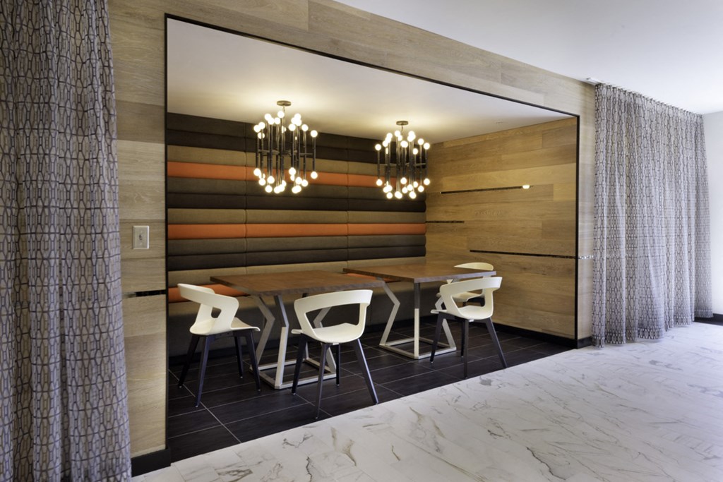 a dining room with a wooden wall and a wooden table with white chairs