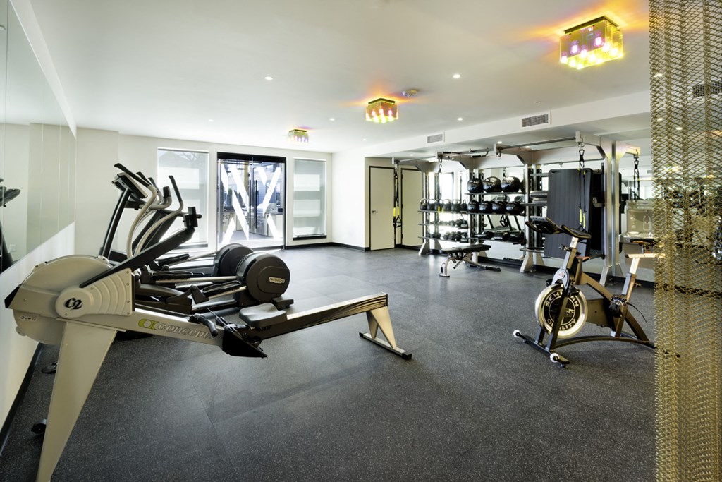 a gym with cardio equipment and weights on the floor