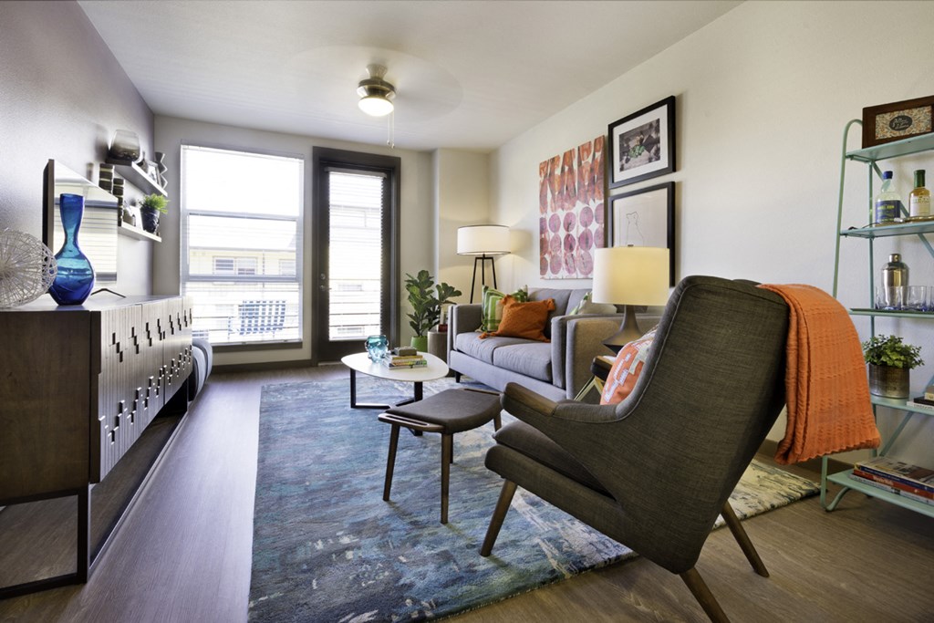a living room with a couch and a chair and a window
