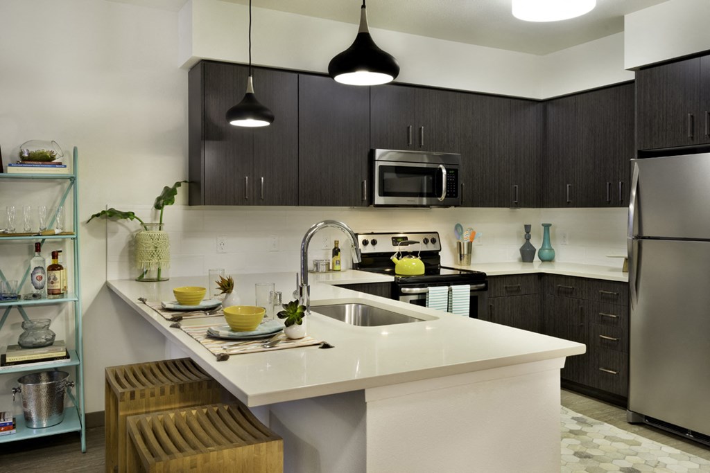 a kitchen with a white counter top and a sink