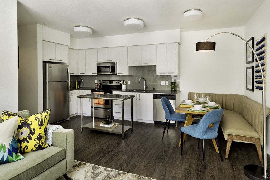 a living room and kitchen with a table and chairs
