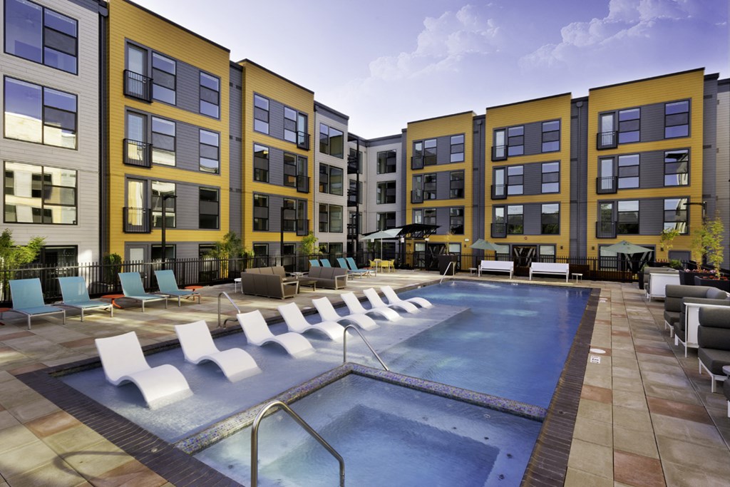 a swimming pool at an apartment building with a pool and lounge chairs