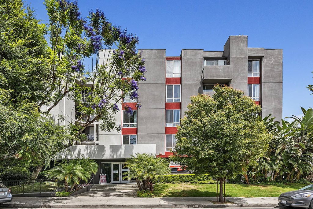 the exterior of a building with trees in front of it
