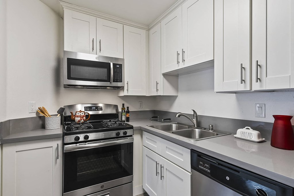 a kitchen with stainless steel appliances and white cabinets