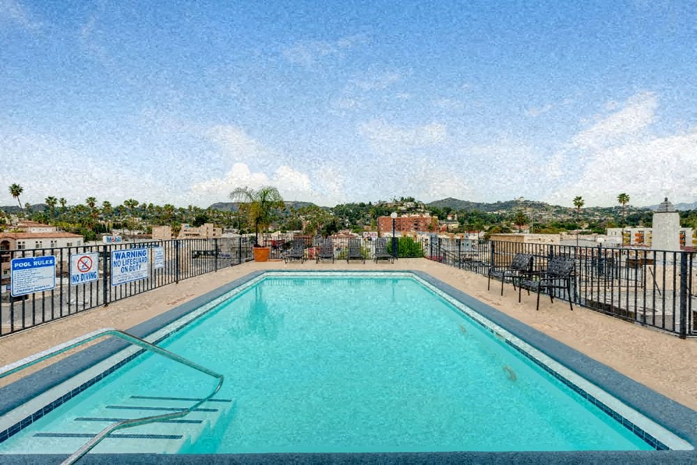 a swimming pool with a fence and a city in the background