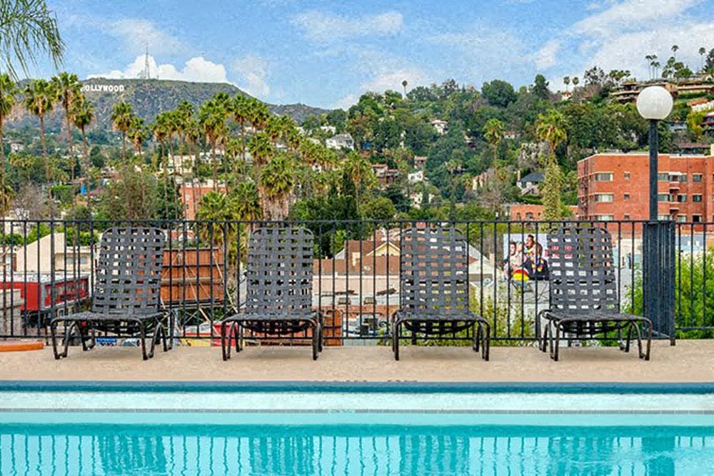 a swimming pool with chairs next to a fence