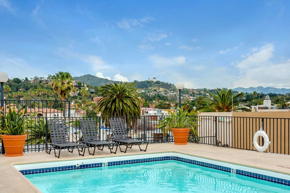 the pool on the roof of a hotel with a view of the city