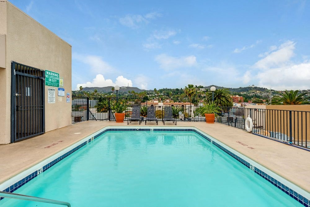 the swimming pool of a hotel with a city in the background