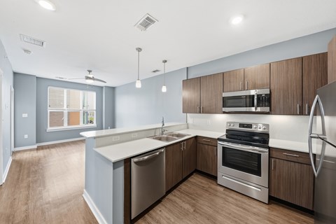 A modern kitchen with stainless steel appliances and wooden cabinets.