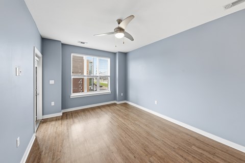 A room with a ceiling fan and a window.