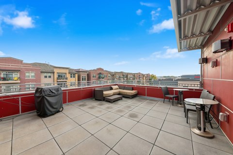 A patio with a table and chairs overlooking a cityscape.