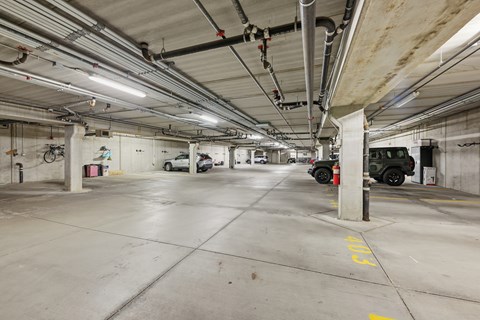 A parking garage with a white truck parked in the distance.