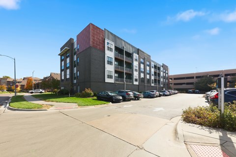 A parking lot in front of a multi-story building.