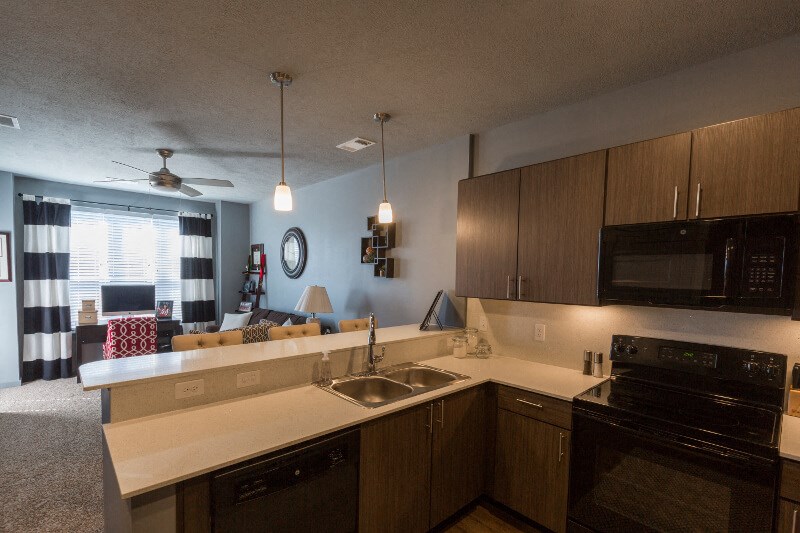 an open kitchen and living room with a couch and a sink