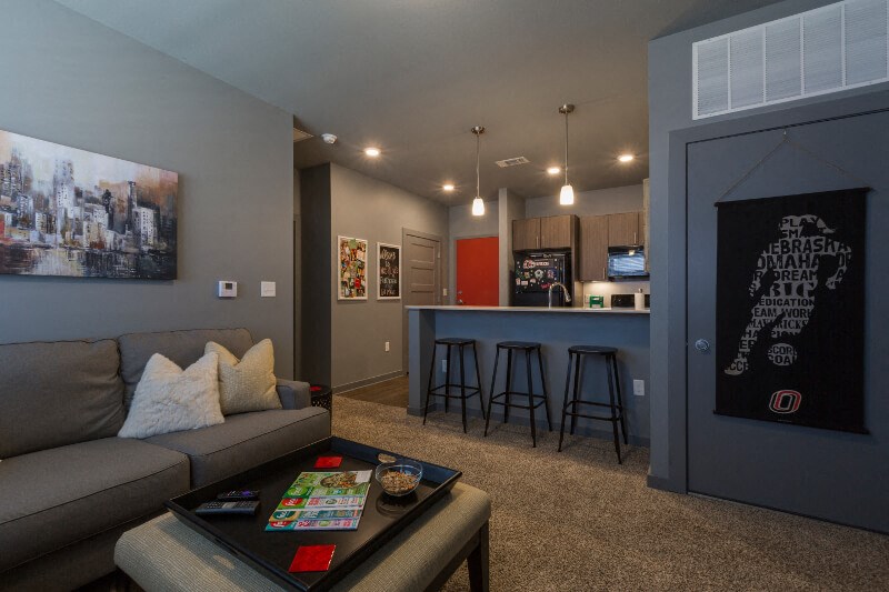 a living room with a couch and a kitchen with a bar