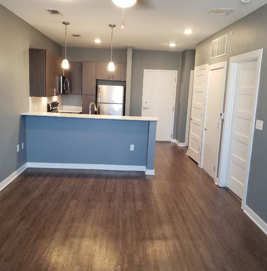 an empty kitchen and living room with a blue counter top