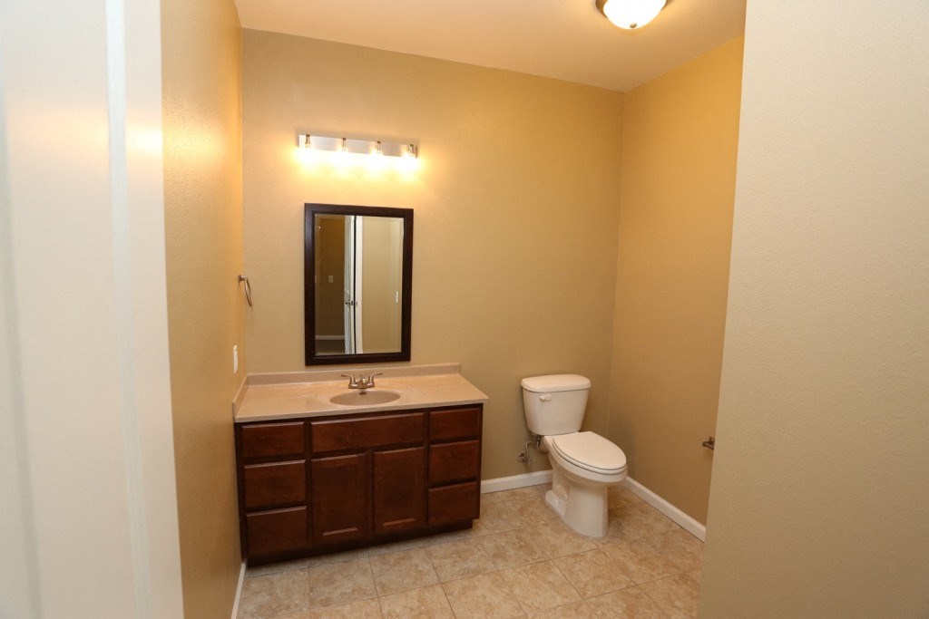 a bathroom with a toilet and a sink and a mirror