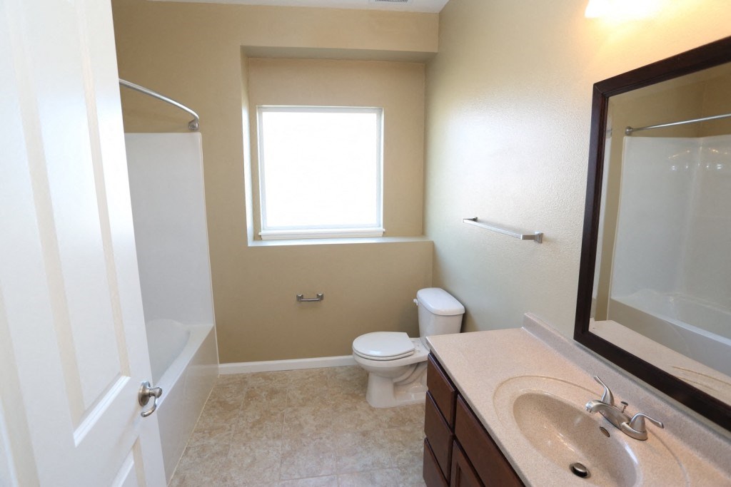 a bathroom with a toilet and a sink and a mirror