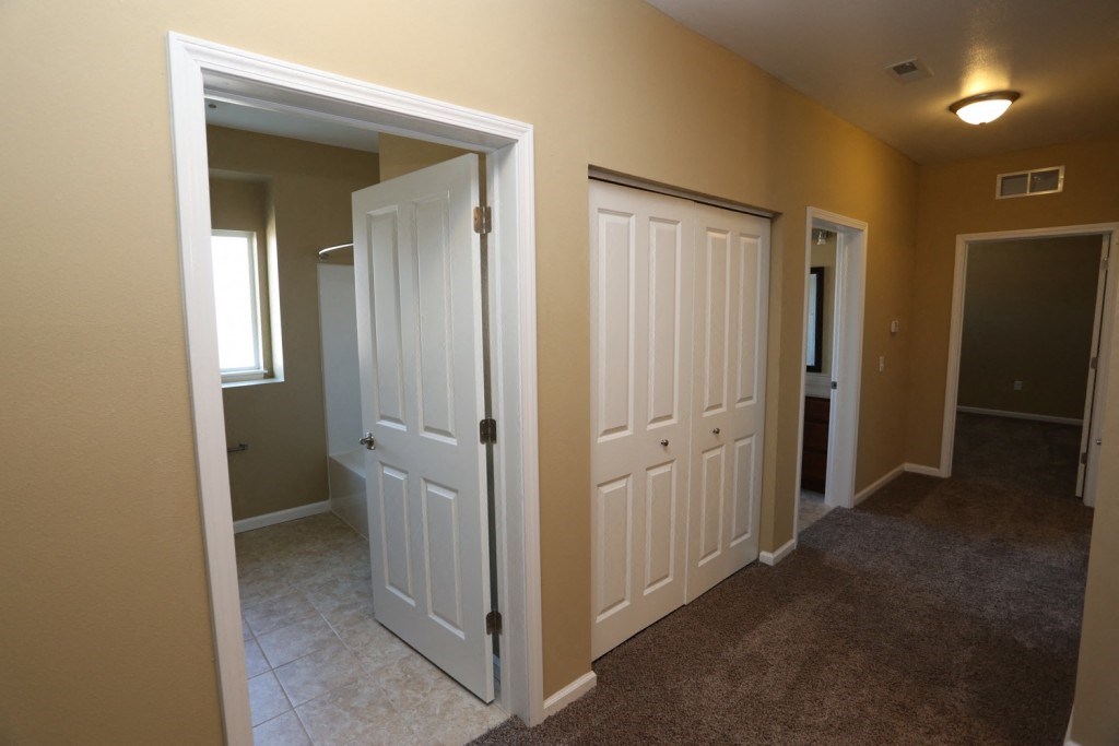 a bedroom with two doors and a hallway with two closets