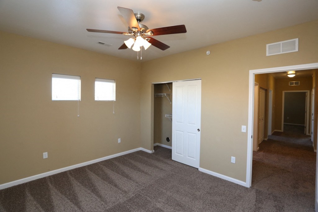 a living room with carpet and a ceiling fan