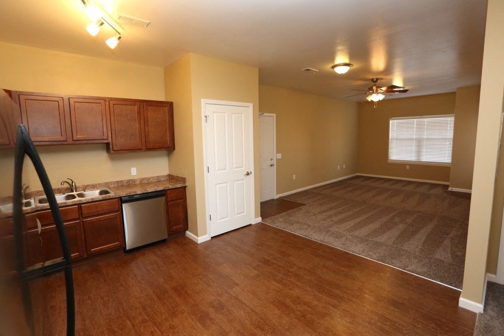 an empty kitchen and living room with wood flooring
