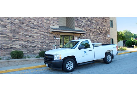 a white truck parked in front of a brick building
