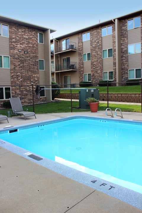 a swimming pool with an apartment building in the background