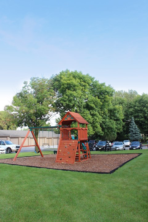a swing set on the grass in a park