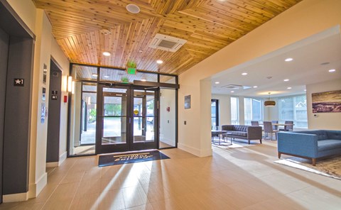 the lobby of a building with glass doors and couches