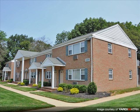 A brick house with a front porch and a covered walkway.